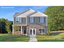 Charming two-story home showcasing stone accents, gray siding, and a well-manicured front lawn at 1386 6Th Street Ne St, Hickory, NC 28601