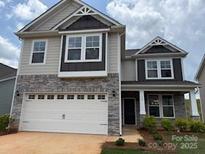 Charming two-story home with stone accents, a two-car garage, and beautifully manicured landscaping at 152 Ella Claire Dr, York, SC 29745