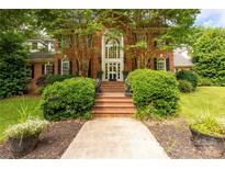 Stately brick home featuring an impressive front entrance with mature trees and manicured landscaping at 1933 Tara Trl, Lancaster, SC 29720
