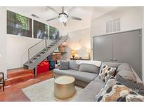 Contemporary living room features a gray sectional sofa and unique metallic coffee table beneath a modern ceiling fan at 297 Mcdonald Ave, Charlotte, NC 28203