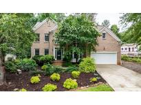 Charming brick home with a lush front yard and attached two-car garage at 4007 Lake Shore S Rd, Denver, NC 28037