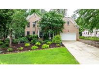 Brick two-story home with mature landscaping, green lawn, and attached two-car garage at 4007 Lake Shore S Rd, Denver, NC 28037