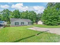Charming single-story home with well-maintained lawn, blue shutters, and a spacious driveway at 425 Austin Dr, Charlotte, NC 28213