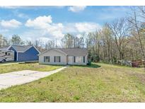 Charming single-story home featuring blue shutters, a concrete driveway, and a well-maintained front lawn at 425 Austin Dr, Charlotte, NC 28213