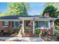 Charming brick home with an American flag, manicured landscaping and brick entryway at 4526 Longwood Dr, Charlotte, NC 28209