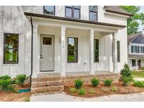 Charming front porch with brick accents, white columns, and freshly landscaped garden bed at 513 Sacco St, Belmont, NC 28012