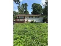 Charming single-story home with a lovely front porch and a partially-covered front yard at 5200 Queen Anne Rd, Charlotte, NC 28217