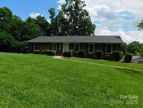 Charming single-story brick home featuring a well-manicured lawn and mature landscaping, perfect for suburban living at 714 Shady Dr, Albemarle, NC 28001