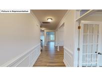 Bright foyer with wood floors, crown molding, and views into the living spaces offers a welcoming entrance at 7172 Sylvan Retreat Dr, Denver, NC 28037