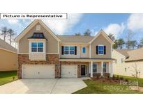 Inviting two-story home featuring a stone and siding facade, a two-car garage and manicured lawn at 7190 Sylvan Retreat Dr, Denver, NC 28037