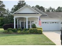 Charming single-story home featuring a well-manicured lawn and inviting covered front porch at 919 Lily Magnolia Ct, Fort Mill, SC 29707