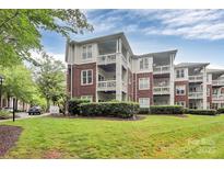 Inviting exterior of brick and siding condo building with well-manicured lawn and lush greenery at 921 Northeast Dr, Davidson, NC 28036