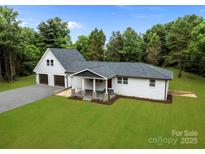 Beautifully landscaped home with a charming front porch and two car garage at 1115 Sides Rd, Salisbury, NC 28146