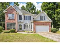 Charming two-story home featuring a brick and siding exterior, lush lawn, and attached two-car garage at 116 Scottie Ct, Rock Hill, SC 29730