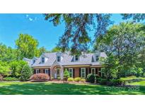 Beautiful red brick home features dormer windows and a perfectly manicured lawn at 1240 Fawn Ridge Nw Rd, Concord, NC 28027