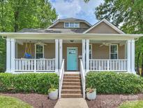Charming home featuring a welcoming front porch with swing and vibrant blue door at 1325 Kennon St, Charlotte, NC 28205