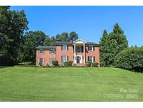 A stately brick home features classic architectural details and lush landscaping on a well-manicured lawn at 1928 Providence Rd, Charlotte, NC 28211