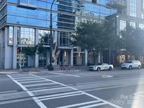 Modern building exterior with glass facade, street view, and pedestrian crosswalk; beautiful urban setting at 333 W Trade St # 505, Charlotte, NC 28202
