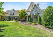 Beautiful stone house featuring manicured front lawn and professional landscaping at 5112 Mill Race Ln, Lancaster, SC 29720