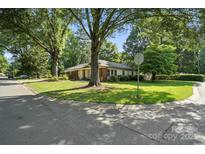 Traditional style house with lush front lawn and mature trees on a sunny day at 5229 Milford Rd, Charlotte, NC 28210