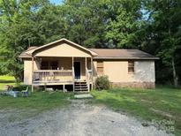 Charming single story home with a covered front porch and gravel driveway surrounded by mature trees at 5881 Robinhood Rd, Fort Lawn, SC 29714