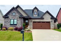 Charming home with a stone and brick facade, manicured lawn, and a two-car garage at 6107 Gold Springs Way, Denver, NC 28037