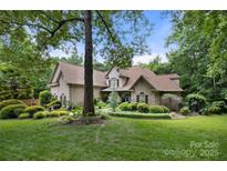 Charming brick home with lush front lawn, mature trees, and manicured landscaping at 849 Savile Ln, Fort Mill, SC 29715
