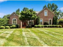 Beautiful brick home featuring a meticulously maintained lawn and mature landscaping at 9027 Kirkley Ct, Charlotte, NC 28277