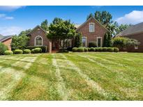 Beautiful brick home featuring manicured lawn and lush landscaping adding to its curb appeal at 9027 Kirkley Ct, Charlotte, NC 28277