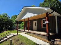 Charming home exterior featuring a covered front porch with wood accents, adding warmth and curb appeal at 94 James Sw St, Concord, NC 28025
