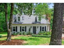 Charming home featuring dormer windows, neutral siding, black shutters and a manicured lawn at 1040 Goshen Pl, Charlotte, NC 28211