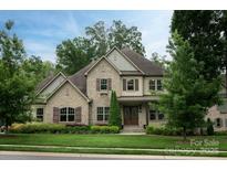 Charming two-story home featuring a stone facade, manicured lawn, and beautiful landscaping at 1233 Ladera Dr, Waxhaw, NC 28173