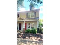 Charming two-story townhome featuring a covered front porch, updated windows, and professionally maintained landscaping at 12450 Stone Garden Dr, Huntersville, NC 28078