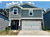 Charming two-story home features gray siding, stone accents, and a two-car garage at 1410 31St Ne St, Conover, NC 28613