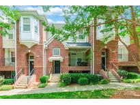 Beautiful brick townhome with covered porch and lush landscaping in a desirable neighborhood at 14222 Richmond Park Ave, Charlotte, NC 28277