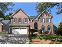 Charming two-story brick home with a manicured lawn and a two-car attached garage at 21514 Gulfstar Ct, Cornelius, NC 28031