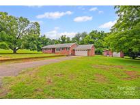 Charming single-story brick home with a spacious front yard and attached garage at 2178 Tryon Courthouse Rd, Bessemer City, NC 28016