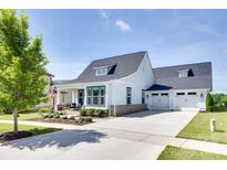 Charming white home featuring a landscaped front yard and a spacious driveway leading to a two-car garage at 264 Auburn View Rd, Rock Hill, SC 29730