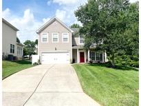 Charming two-story home features a well-manicured lawn, long driveway, and a vibrant red front door at 4048 Cascade Dr, Gastonia, NC 28056