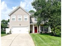 Charming two-story home featuring a red front door, well-manicured lawn, and a two-car garage at 4048 Cascade Dr, Gastonia, NC 28056