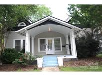 Charming home featuring a covered front porch with white pillars and blue painted steps at 510 5Th St, Spencer, NC 28159