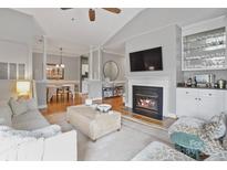 Open-concept living room with fireplace, built-in bar, and hardwood floors at 5730 Closeburn Rd # N, Charlotte, NC 28210