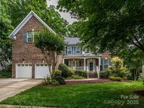 Charming brick home features an attached two-car garage and a well-manicured front yard at 9212 John Hawks Rd, Cornelius, NC 28031