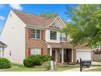 Inviting two-story home featuring brick and vinyl siding, red shutters, landscaped front yard, and an attached two-car garage at 9429 Coast Laurel Nw Ave, Concord, NC 28027