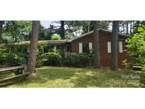 Quaint brick house with mature trees and a picnic table sitting in the front yard at 1116 Bryce Ave, Salisbury, NC 28144