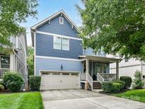 Charming two-story home with blue siding, a two-car garage, and a welcoming front porch at 1118 Yale Pl, Charlotte, NC 28209