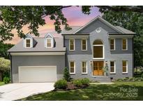 Charming two-story home with a well-maintained lawn, attached garage, and beautiful architectural details at 12411 Herdon Ct, Charlotte, NC 28277