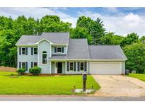 Charming two-story home features a well-manicured lawn, mature trees, and an attached two-car garage at 12812 Bradford Hill Ln, Huntersville, NC 28078