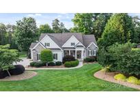 Charming home with a well-manicured lawn, stone accents, and mature trees at 132 Ragsdale Trl, Mooresville, NC 28117