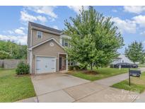 Charming two-story home with landscaped front yard, paved driveway, and attached one car garage at 1404 Waylon Ave, Gastonia, NC 28054
